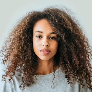 Femme noire aux cheveux frisés chatains clairs