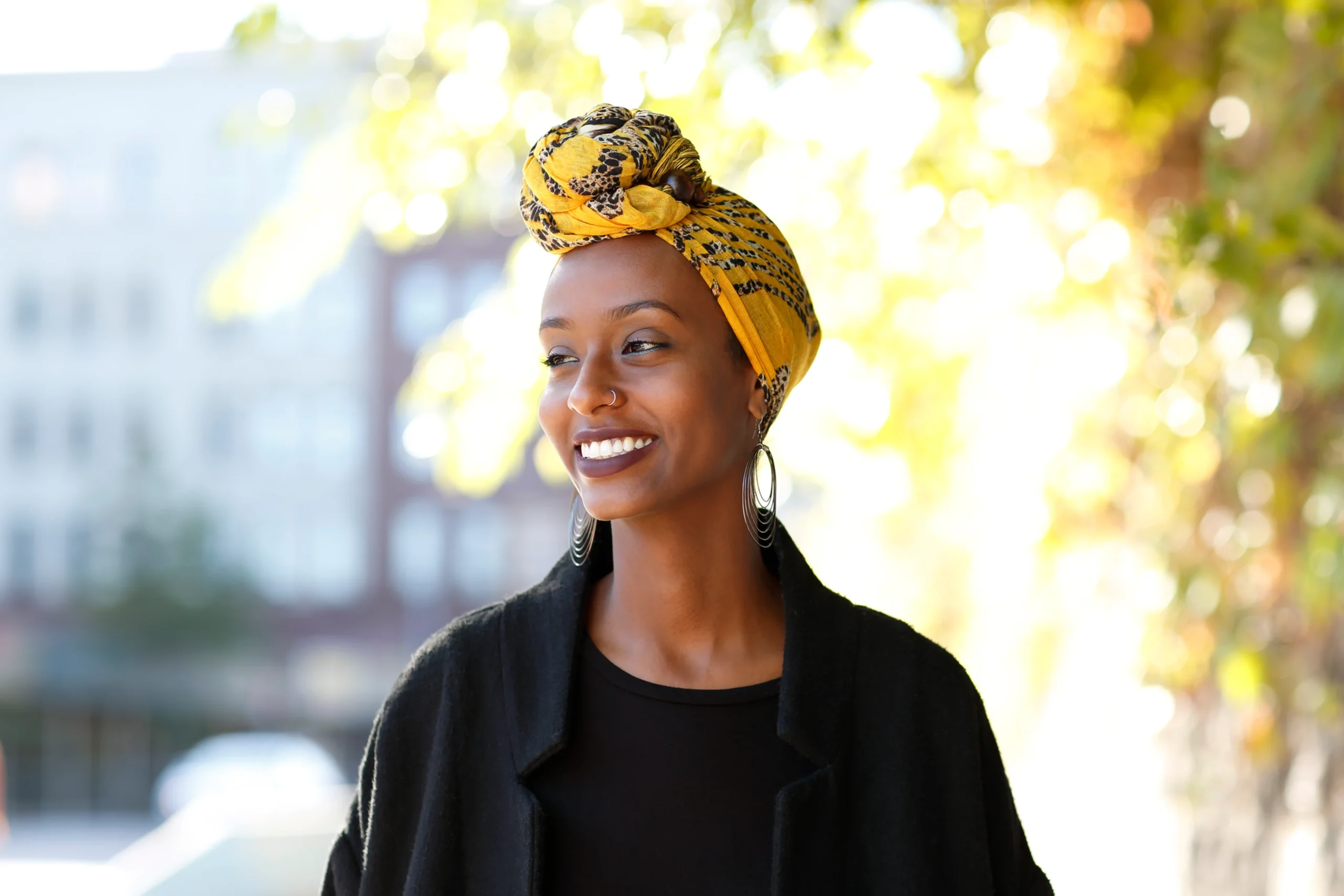 Femme noire souriante coiffée d'un turban jaune - Affirmations positives estime de soi